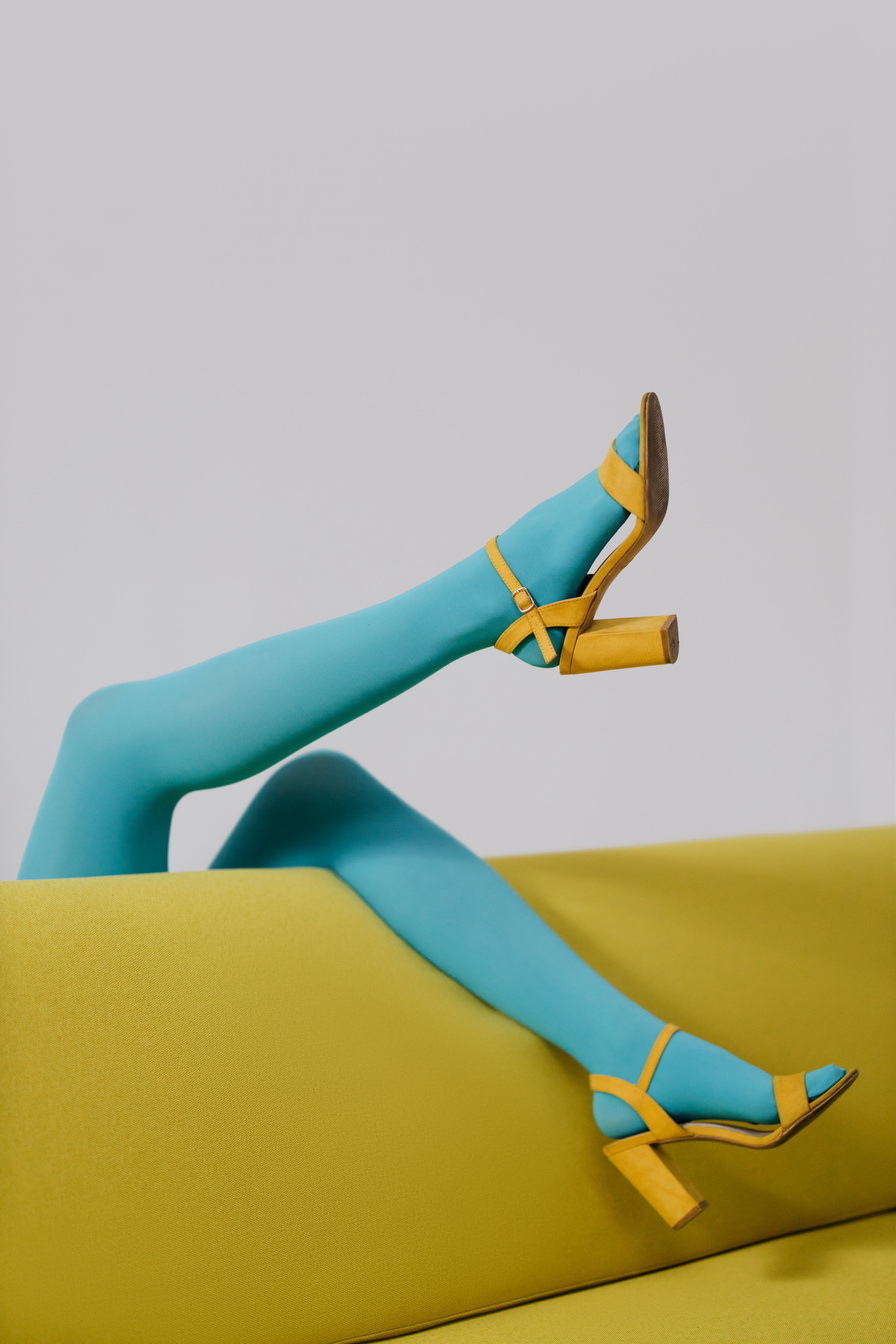 Woman in Blue Leggings Lying on Yellow Chair